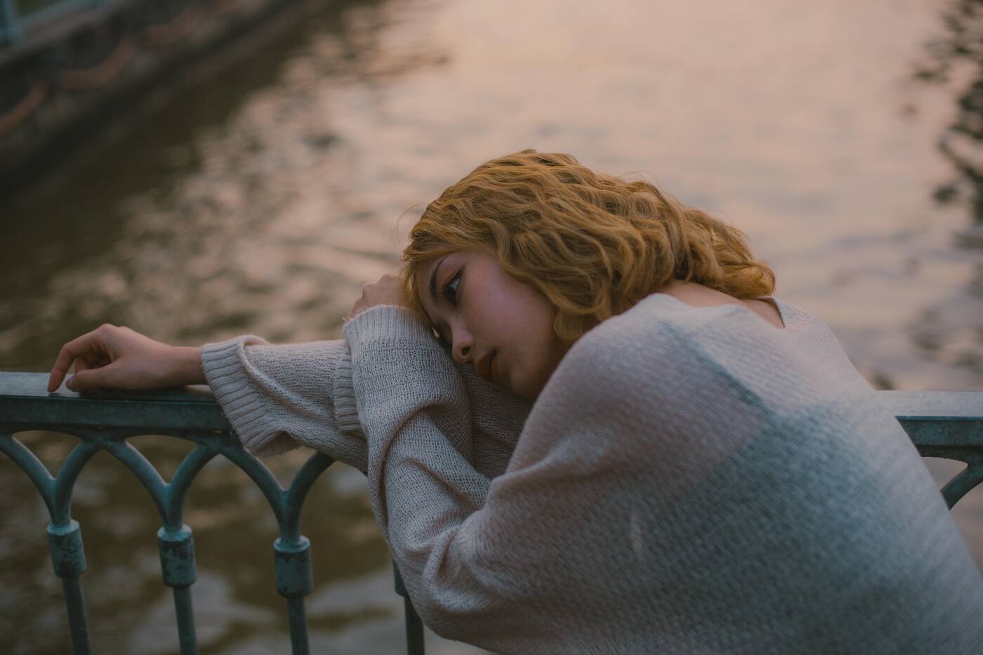 A person sitting quietly by a window in soft light, representing the experience of depression