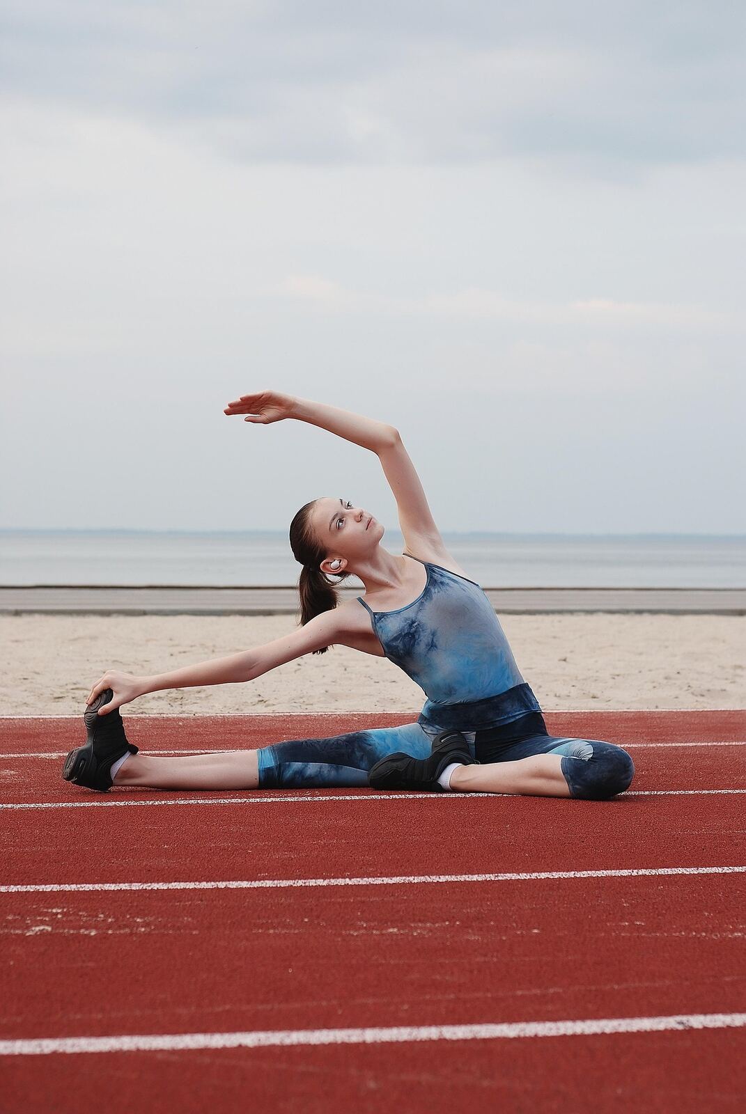 Young woman stretching calmly on a running track representing gentle exercise for depression recovery