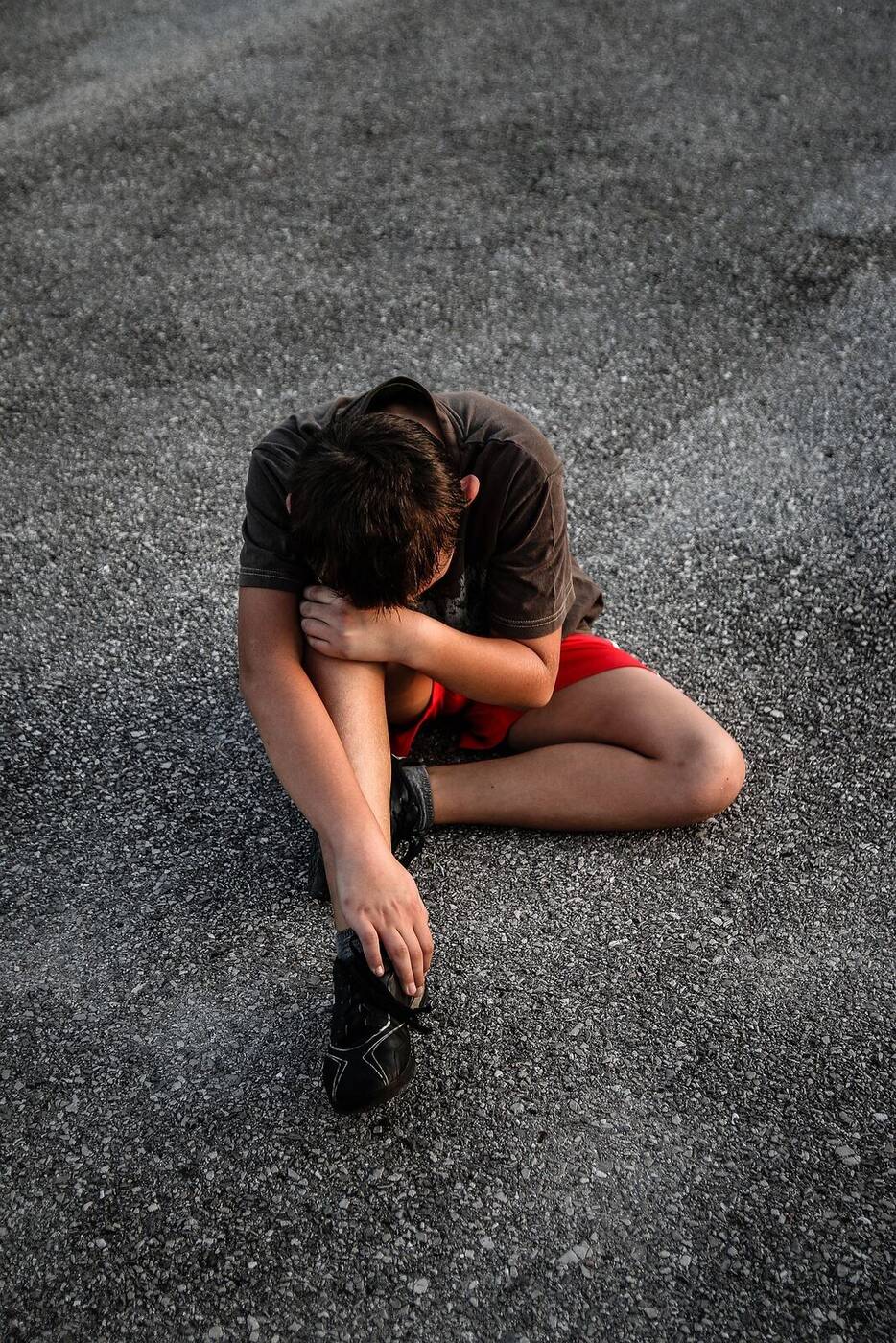 A young boy sitting alone representing generational trauma