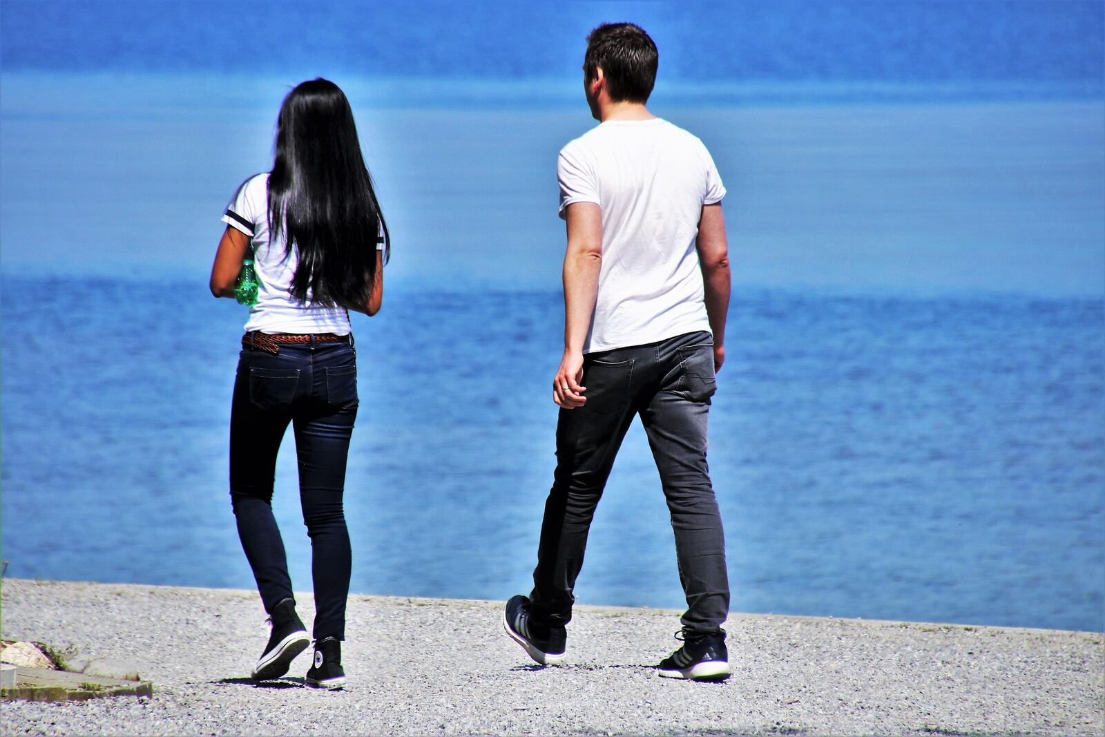 Couple walking side by side by a lake representing emotional connection in relationships